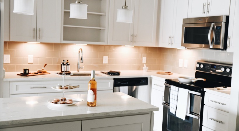 Spacious and well lit kitchen with wood flooring and stainless steel appliances